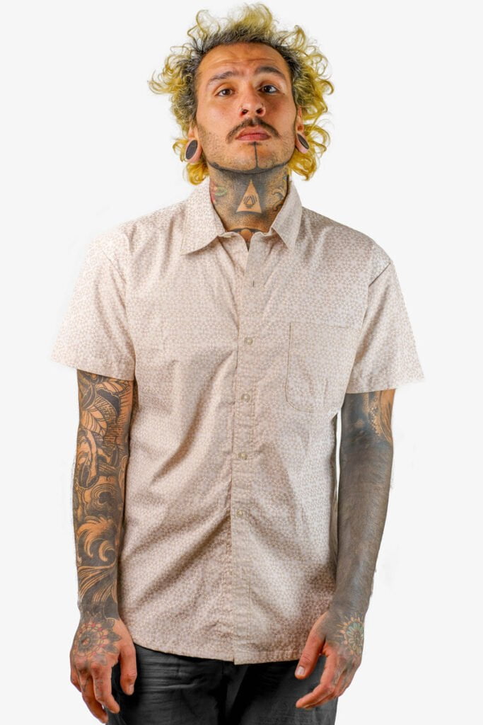 Beige Solar Grid, a uniquely designed short-sleeved button-up shirt for men, is available from Avanyah's online store and showcases wearable screen-printed art that is ideal for festival fashion and alternative statement lovers